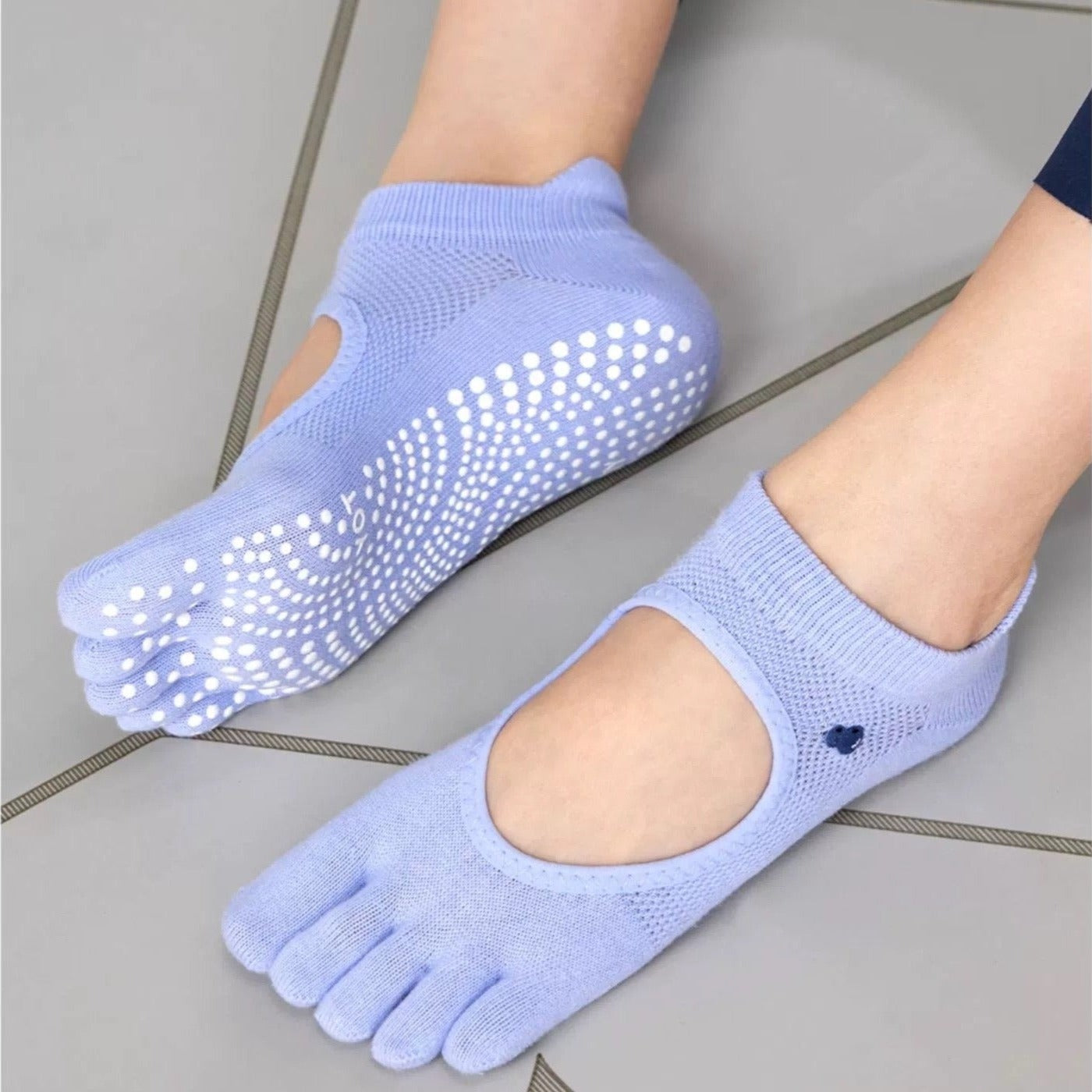 A pair of brown toeless non-slip grip socks with a pattern of white circles on the sole and a red cherry on the ankle support band.